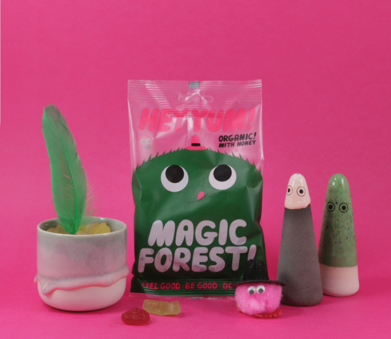 HEY YUM! Magic Forest bomboni s medom, pakiranje na ružičastoj pozadini uz dekoracije i figurice