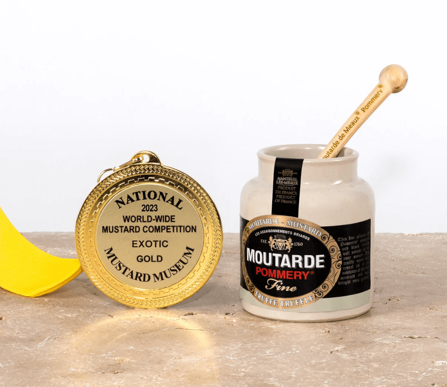 Staklenka Pommery Moutarde Fine senfa s tartufima s drvenom žličicom, prikazana uz zlatnu medalju “World-Wide Mustard Competition 2023 – Exotic Gold”