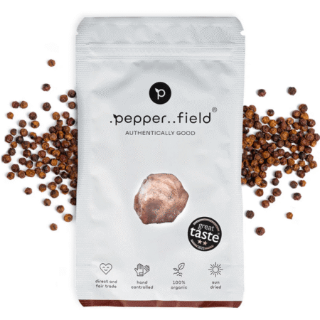 Pakiranje crvenog Kampot papra Pepper..field okruženo zrncima papra